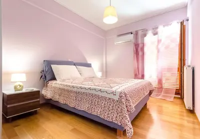 a bedroom with a bed and a window at Leo - Unique Glyfada Apartment in Athens