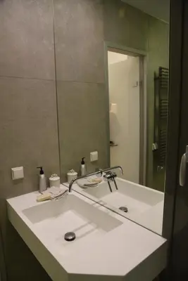 a bathroom with a sink with a large mirror at Acropolis At Your Door in Athens