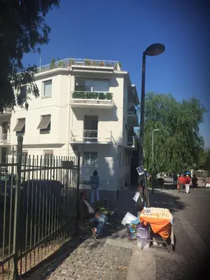 a man sitting in front of a white building at Acropolis At Your Door in Athens
