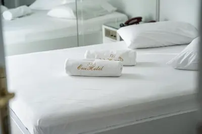 two towels sitting on top of two white beds at Eva Hotel Piraeus in Piraeus