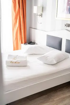 two beds in a room with white sheets and pillows at Eva Hotel Piraeus in Piraeus