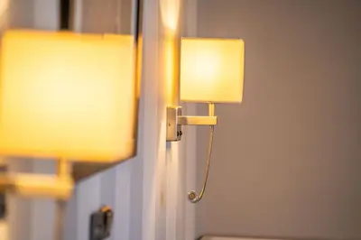 a lamp on a wall next to a mirror at Eva Hotel Piraeus in Piraeus