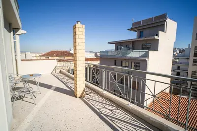 a balcony with a table and chairs on a building at Eva Hotel Piraeus in Piraeus