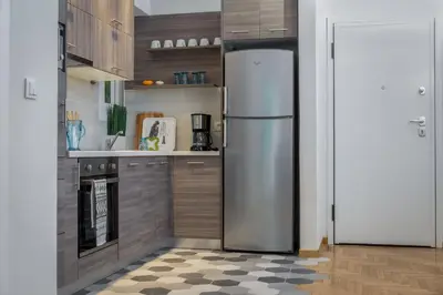 a stainless steel refrigerator in a kitchen with a checkered floor at Absolute Athens II in Athens