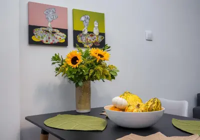 a table with a vase of flowers and a bowl of fruit at Absolute Athens II in Athens