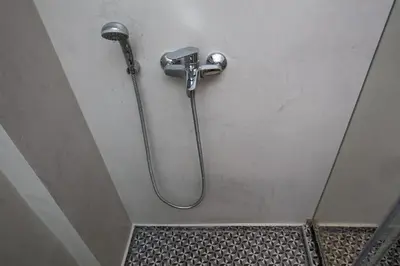 a shower with a hose attached to a wall at Absolute Athens II in Athens