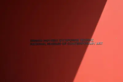 a red wall with a sign that readsnatural museum of contemporary art at Absolute Athens II in Athens