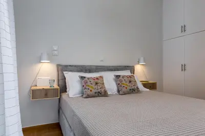 a bedroom with a large bed with white walls and pillows at Absolute Athens II in Athens