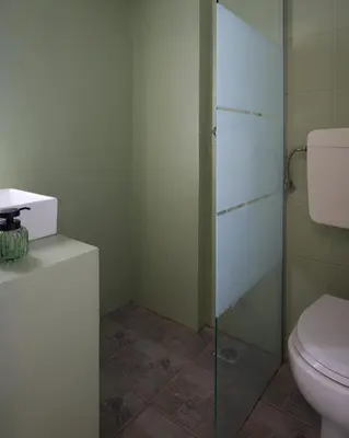 a bathroom with a toilet and a glass shower at Alpha Residence in Athens