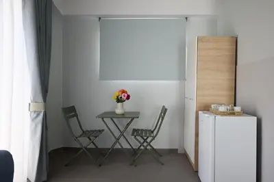 a table and chairs in a room with a refrigerator at Alpha Residence in Athens