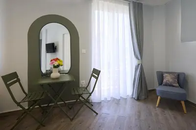 a room with a mirror and a table and chairs at Alpha Residence in Athens