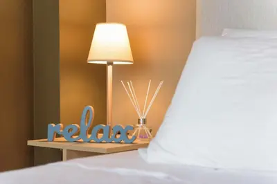 a table with a lamp next to a bed at Armoniko in Athens