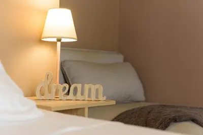 a room with a bed and a table with a lamp at Armoniko in Athens