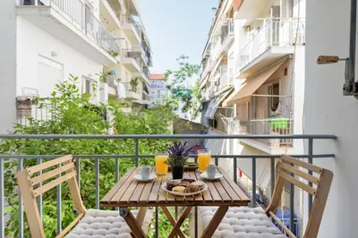 a balcony with a table and chairs on a balcony at Armoniko in Athens
