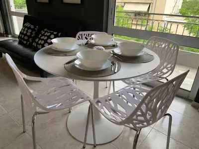 a white table with four chairs and bowls on it at Sepolia Apartment in Athens