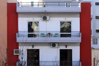 a white and red building with a balcony at Sepolia Apartment in Athens