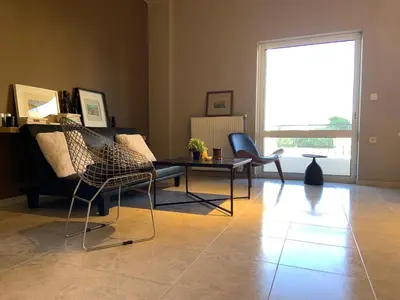 a living room with a couch and a table and chairs at Sepolia Apartment in Athens