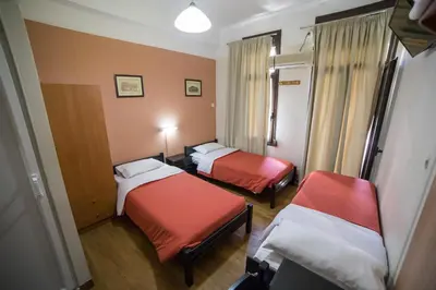 a room with two beds and two chairs at Tempi Hotel in Athens