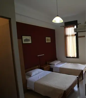 a hotel room with two beds and a window at Tempi Hotel in Athens