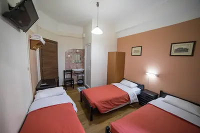 a hotel room with two beds and a television at Tempi Hotel in Athens