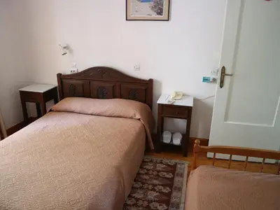 a bedroom with two beds and a phone on the wall at Acropolis House Hotel Classic in Athens