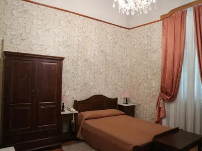a bedroom with a bed and a cabinet and a chandelier at Acropolis House Hotel Classic in Athens