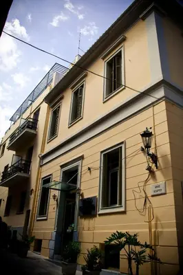 a yellow building with windows and a balcony at Acropolis House Hotel Classic in Athens