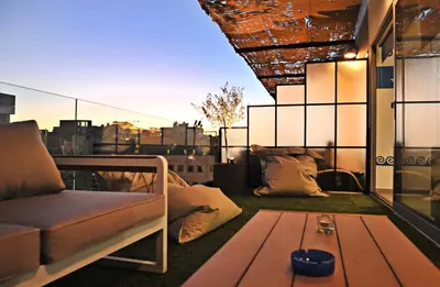 a living room with a couch and a table on a balcony at The Athenians Modern Apartments in Athens