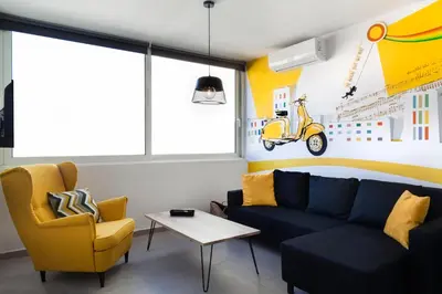 a living room with a blue couch and a yellow chair at The Athenians Modern Apartments in Athens