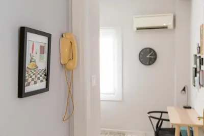a phone hanging on a wall next to a room at Gazi Area close to Subway in Athens