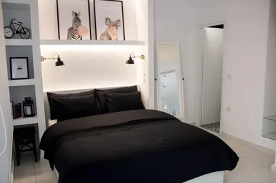 a bedroom with a black bed with pictures on the wall at Super Stylish Apartments in Syntagma Square! in Athens