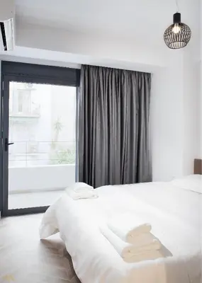 a bedroom with a white bed and a window at Elysium Boutique Apartments in Athens