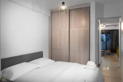 a bedroom with a white bed with a wooden wall at Elysium Boutique Apartments in Athens