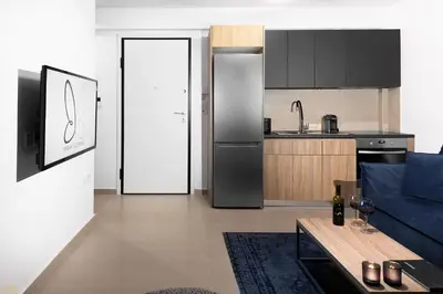 a kitchen with a refrigerator and a blue couch at Elysium Boutique Apartments in Athens