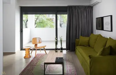 a living room with a green couch and a table at Elysium Boutique Apartments in Athens