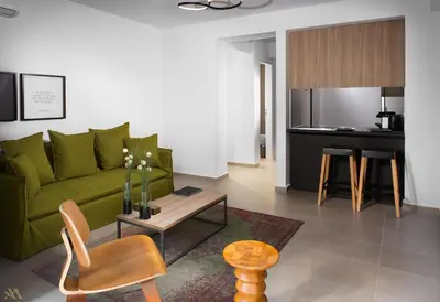 a living room with a green couch and a table at Elysium Boutique Apartments in Athens
