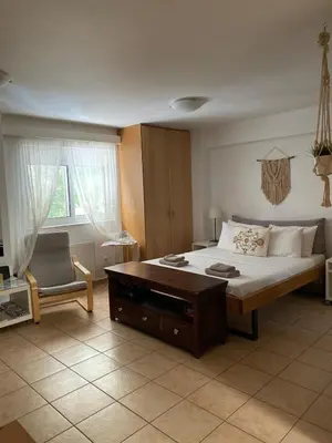 a bedroom with a large bed and a chair at The Little Studio Koukaki - Acropolis in Athens