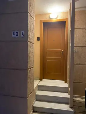 a hallway with a brown door and stairs at The Little Studio Koukaki - Acropolis in Athens
