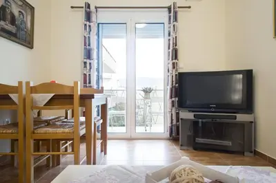 a living room with a television and a dining room table at Acropolis Heart in Athens