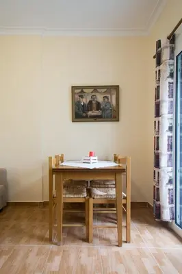 a dining room table with chairs and a painting on the wall at Acropolis Heart in Athens