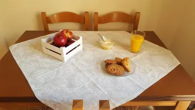 a table with a plate of fruit and a glass of orange juice at Acropolis Heart in Athens