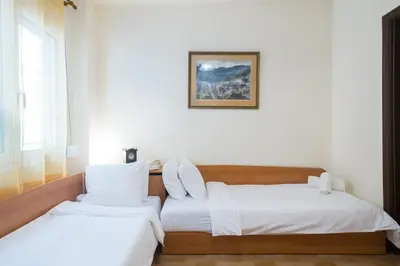 a bedroom with two beds and a picture on the wall at Acropolis Heart in Athens