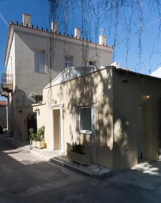 a white house with a shadow on the side of it at The Little Prince in Plaka in Athens