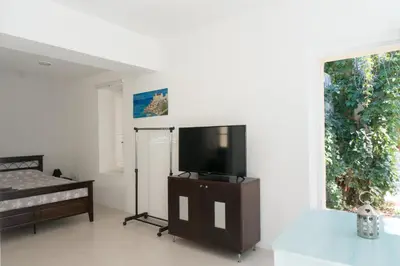 a living room with a flat screen tv on a stand at The Little Prince in Plaka in Athens