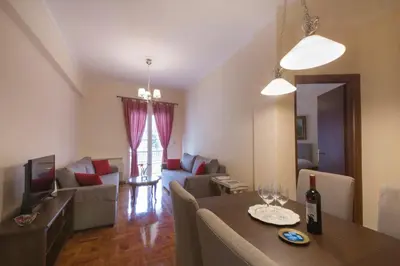 a living room with a table and a living room with a couch at Keramikos Cozy Apartment by YHA in Athens
