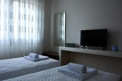a bedroom with two beds and a flat screen tv at Alke Homme in Athens