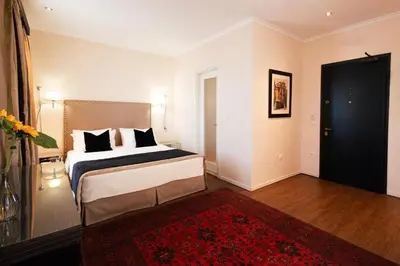 a bedroom with a bed and a red rug at Best Western Plus Embassy Hotel in Athens