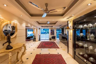 a living room with a ceiling fan and a red rug at Best Western Plus Embassy Hotel in Athens