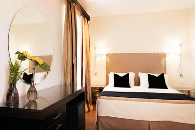 a bedroom with a bed with a mirror and a table at Best Western Plus Embassy Hotel in Athens