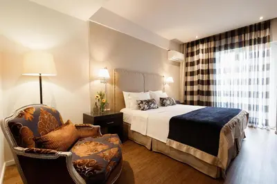 a hotel room with a bed and a chair at Best Western Plus Embassy Hotel in Athens